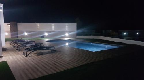 a swimming pool at night with a bunch of chairs around it at Maximos Luxury Villa with Pool -BREAKBOOKING-CY in Limassol