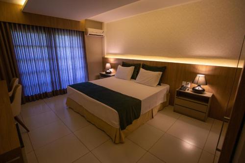 En eller flere senger på et rom på Hotel Águas Claras