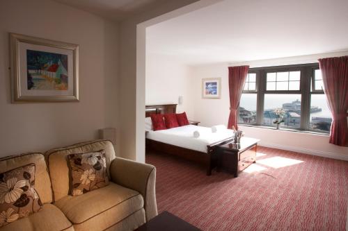 um quarto com uma cama, um sofá e uma janela em Park Central Hotel em Bournemouth
