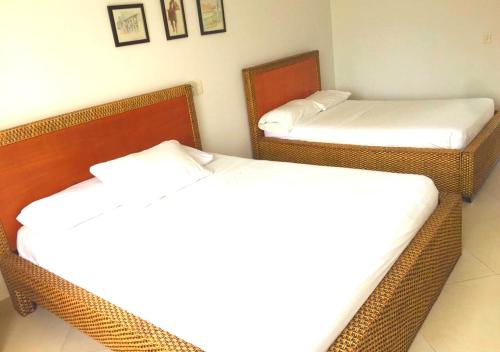 two wicker beds in a room with two mirrors at Casa Campestre con Piscina Privada Anapoima in Girardot