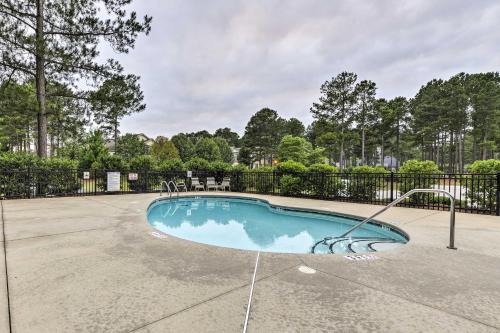 an empty swimming pool with a fence and trees at Resort-Style Condo on Golf Course with Pool Access in Spring Lake