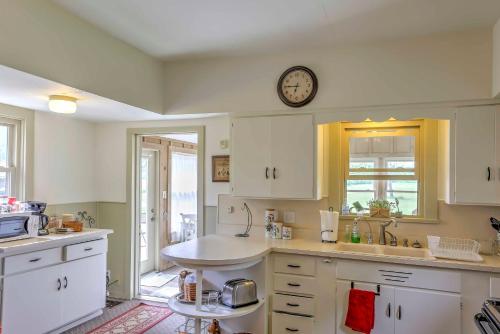 una cocina con armarios blancos y un reloj en la pared en Historic Ottawa Lake House Deck, Barn and 96 Acres!, en Sylvania