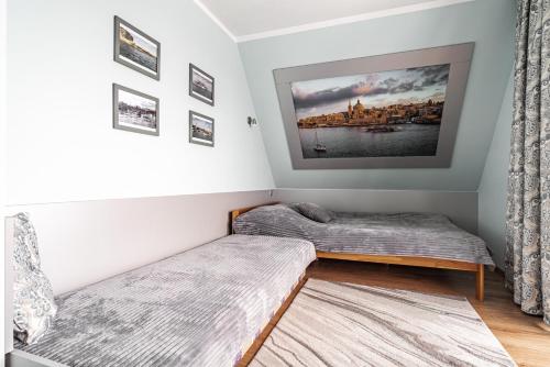 a bedroom with two beds and a tv on the wall at Willa Jaś I Małgosia in Kościelisko
