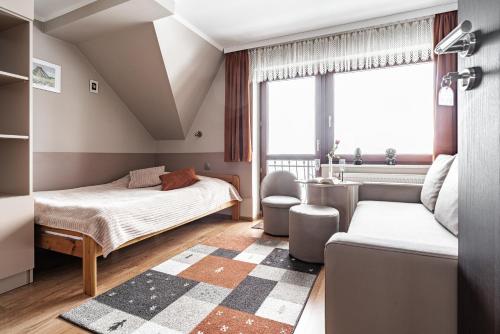 コシチェリスコにあるWilla Jaś I Małgosiaのベッドルーム1室(ベッド2台、ソファ付)