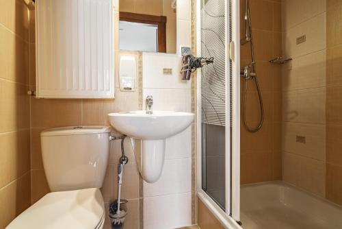 a bathroom with a toilet and a sink and a shower at Willa Jaś I Małgosia in Kościelisko