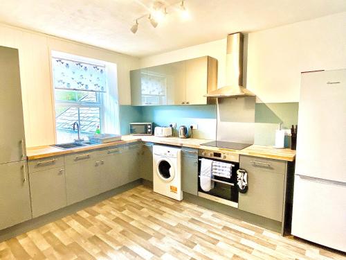 a kitchen with a washer and dryer in it at Hiraeth Môn in Menai Bridge