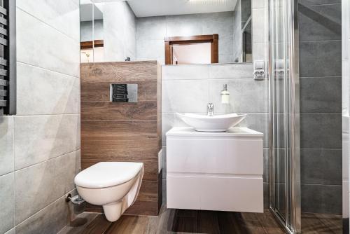 a bathroom with a white toilet and a sink at Willa Jaś I Małgosia in Kościelisko