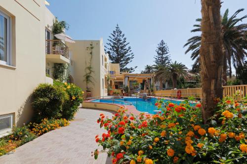 a resort with a swimming pool and some flowers at Lambrinos Suites in Platanias