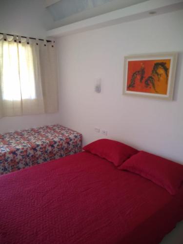 a bedroom with a red bed and a window at Pousada Canto dos Canários in Socorro