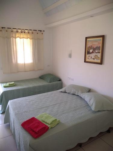 a bedroom with two beds and a window at Pousada Canto dos Canários in Socorro