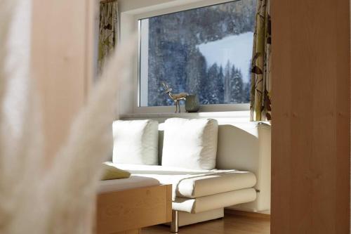 a window with a couch in front of a window with a deer statue at Apart Mount Everest in Sölden