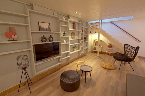 a living room with a tv and a staircase at Jacuzzi & Sauna Villa 2 in Tzummarum