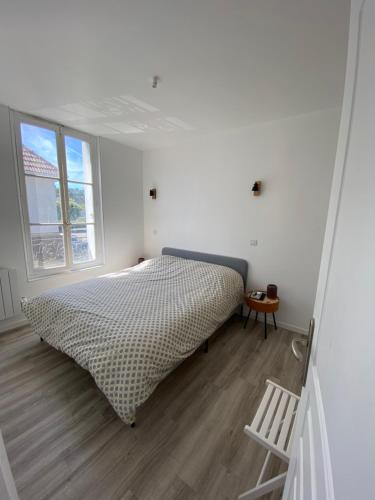ein weißes Schlafzimmer mit einem Bett und einem Fenster in der Unterkunft Cosy Flat Carteret - Appartement centre bourg - 4 personnes in Barneville-Carteret