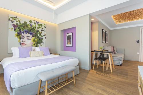 een slaapkamer met een groot bed en een schilderij van een vrouw bij Artree Suites in Heraklion