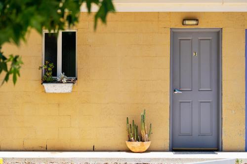 a house with a blue door and a window at The Albion Motel Castlemaine in Castlemaine