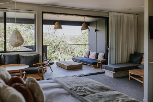 a living room with a couch and a table at Ocean Suites Byron Bay in Byron Bay