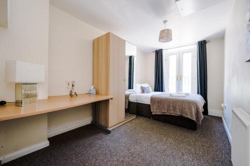 a bedroom with a bed and a desk and a window at Liverpool City Centre - Spacious Duplex - 6 Bedrooms - Sleeps 14 People in Liverpool