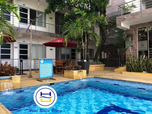 a swimming pool with a sign in front of a building at Hotel Único Plaza in Villavicencio