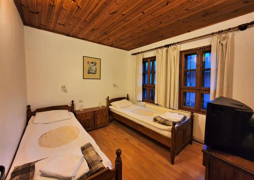 1 dormitorio con 2 camas y TV. en Yakovtsi Inn, en Yakovtsi