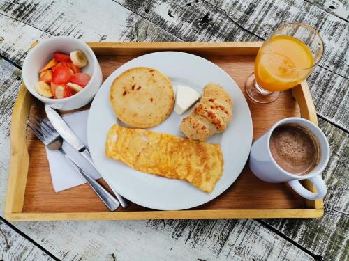 a tray with a plate of breakfast food and a cup of coffee at Eco Hotel Terrabella in Santa Elena