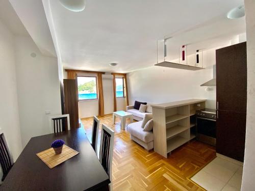 a kitchen and living room with a table and a couch at Apartments First Line in Petrovac na Moru
