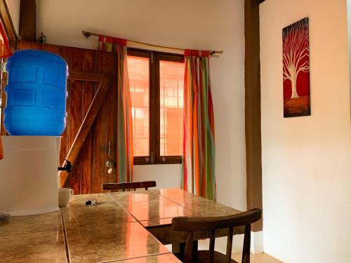 a dining room with a glass table and chairs at La posada de Mary in Montañita