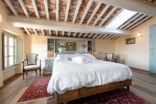 um quarto com uma grande cama branca e uma secretária em Terre di Cocomo em Borgo a Buggiano