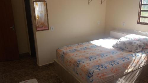 een kleine slaapkamer met een bed in een kamer bij ApartHotel Família Meireles in Luziânia