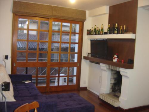 uma sala de estar com um sofá e uma lareira em GringsApsAluguel204 em Gramado