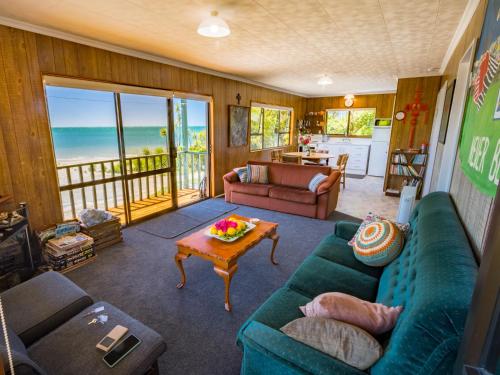 a living room with blue couches and a table at Tidal Treasure - Collingwood Holiday Home in Collingwood