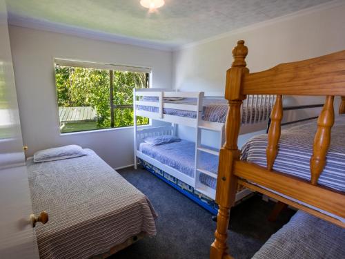 a bedroom with two bunk beds and a window at Tidal Treasure - Collingwood Holiday Home in Collingwood