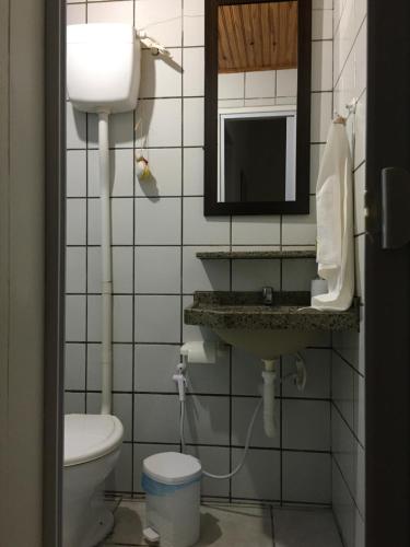 a bathroom with a toilet and a sink and a mirror at Chales Adria in Porto De Galinhas