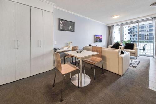 a living room with a table and a couch at The Capitol Apartments in Brisbane