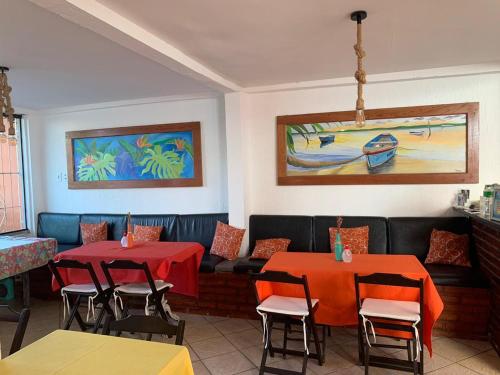a restaurant with two tables and chairs and a couch at Nova Aldeia Buzios in Búzios