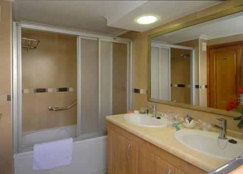 a bathroom with a shower and a sink and a mirror at Beverly Hills Suites - Excel Hotels & Resorts in Los Cristianos