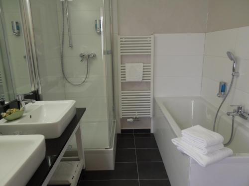 a bathroom with a sink and a shower and a tub at Hotel Mutiger Ritter in Bad Kösen