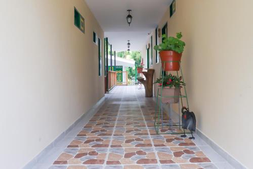 a hallway with a tiled floor with potted plants at Refugio El Abuelo in Santa Rosa de Cabal