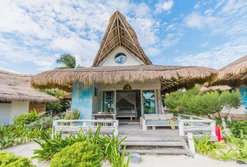 a house on the beach with a thatched roof at Kai Tulum in Tulum