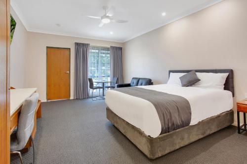 a hotel room with a bed and a desk at Manifold Motor Inn in Camperdown