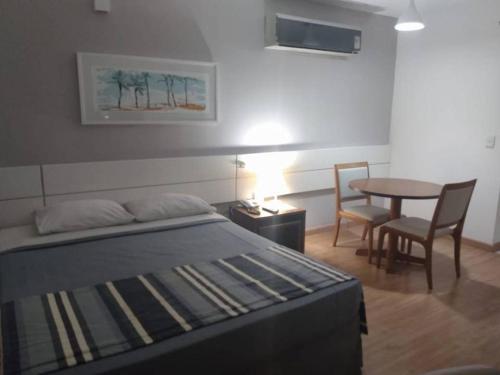 - une chambre avec un lit, une table et des chaises dans l'établissement Salvador Business & Flat propriedade, à Salvador