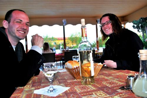 a man and woman sitting at a table with a bottle of wine at Hotel Dort Mevsim in Pamukkale