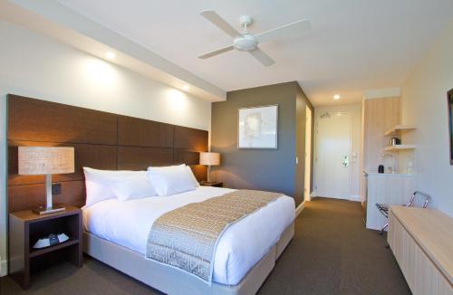 a bedroom with a large bed and a ceiling fan at The Remington Muswellbrook in Muswellbrook