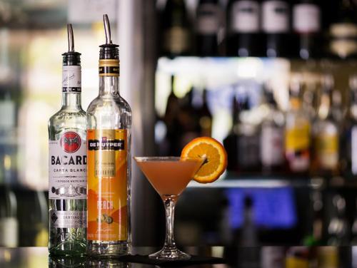 two bottles of alcohol and a martini glass with an orange slice at The Remington Muswellbrook in Muswellbrook
