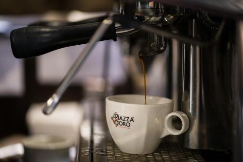 a coffee maker pouring coffee into a coffee cup at The Remington Muswellbrook in Muswellbrook