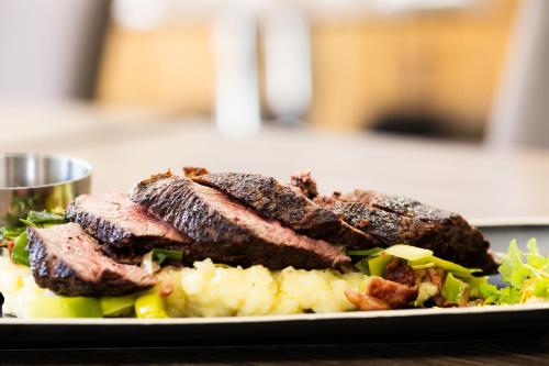 a plate of food with meat and vegetables on a table at The Remington Muswellbrook in Muswellbrook
