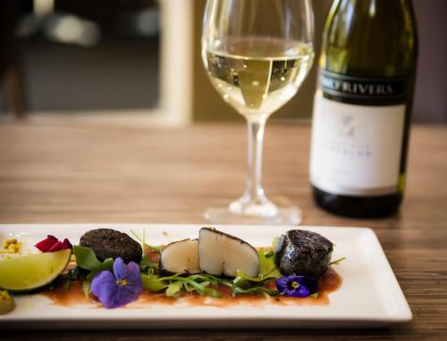 a plate of food and a glass of wine at The Remington Muswellbrook in Muswellbrook