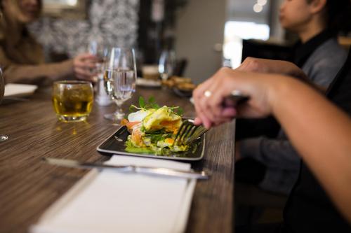 a plate of food on a table with a person eating at The Remington Muswellbrook in Muswellbrook
