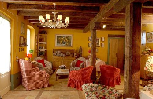 a living room with chairs and a table and a chandelier at Maso Di Villa Relais di Campagna in Susegana