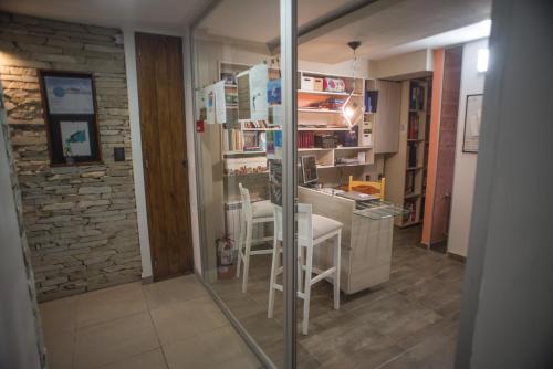 a kitchen with a counter with a stool in a room at Amares Apart - Departamentos 1 y 2 in Santa Clara del Mar