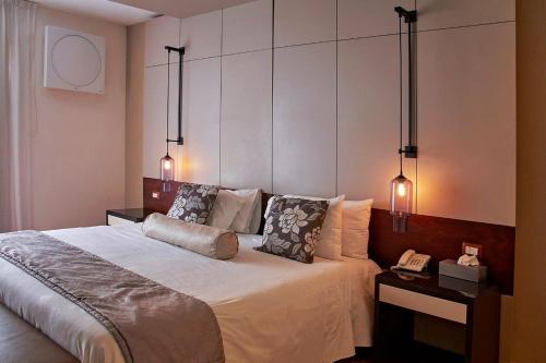 een slaapkamer met een groot bed met 2 lampen bij Alesia - Boutique Hotel & Spa in Aguascalientes